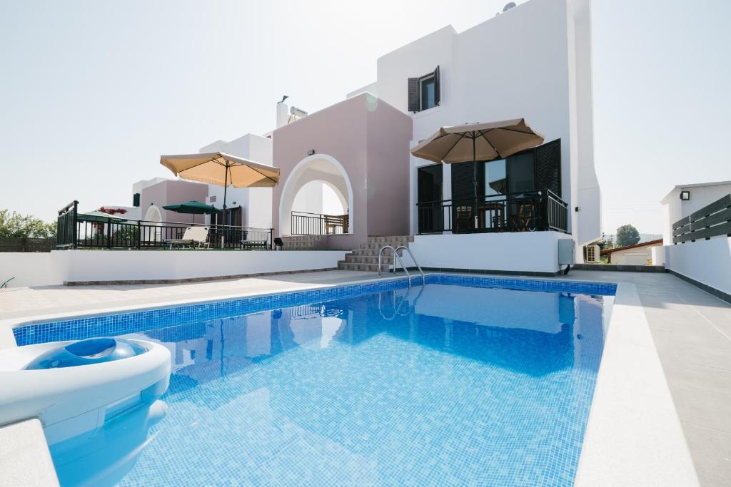 une villa avec une piscine et une maison dans l'établissement Villa Irini & Villa Vasiliki, à Afantou