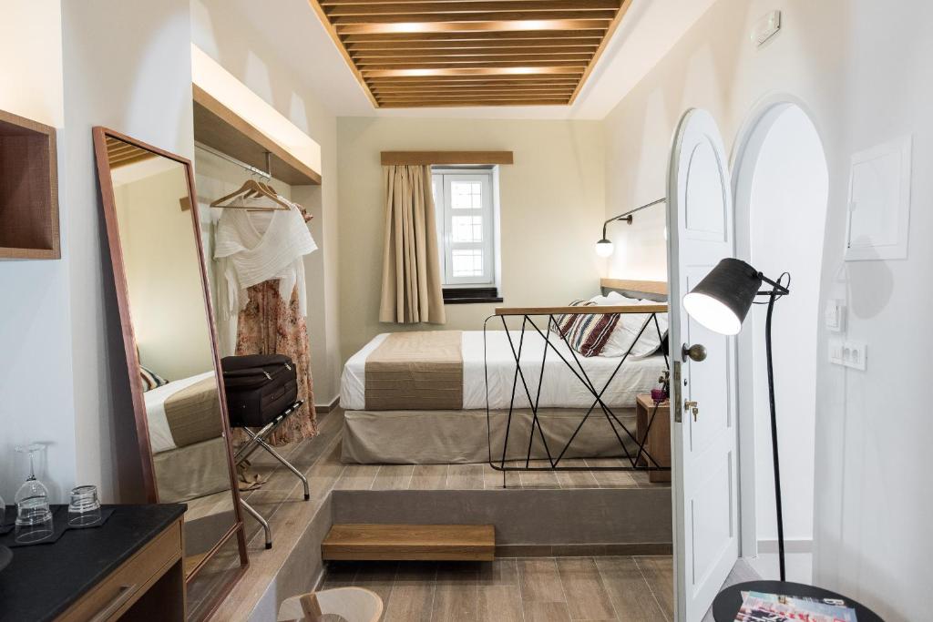 ein Hotelzimmer mit einem Bett und einem Spiegel in der Unterkunft Harismari Cozy Hotel in Chania