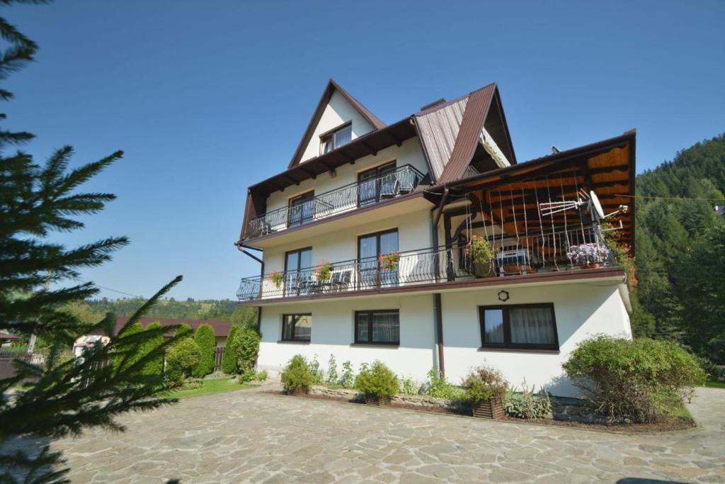 a large white building with a balcony at Gospodarstwo Agroturystyczne Watra in Koninki