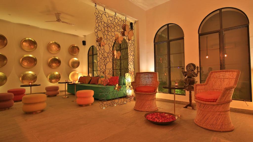 een woonkamer met stoelen en een muur met borden bij Villa 243 in Jaipur