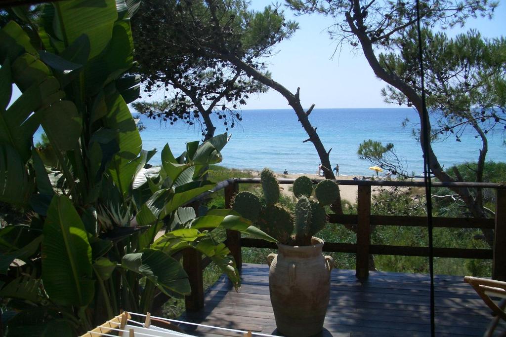 
a wooden bench sitting on top of a sandy beach at Esclusiva suite Il nido d'amore sul mare in Gallipoli
