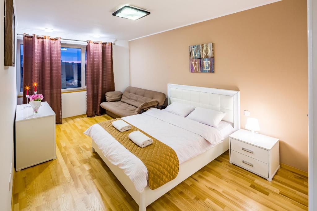 リヴィウにあるBv Apartments Svobodu Avenueのベッドルーム(大きな白いベッド1台、ソファ付)