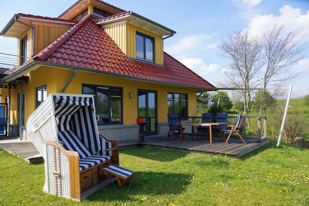 a house with a deck and a table and chairs at Det gule Hus in Kappeln