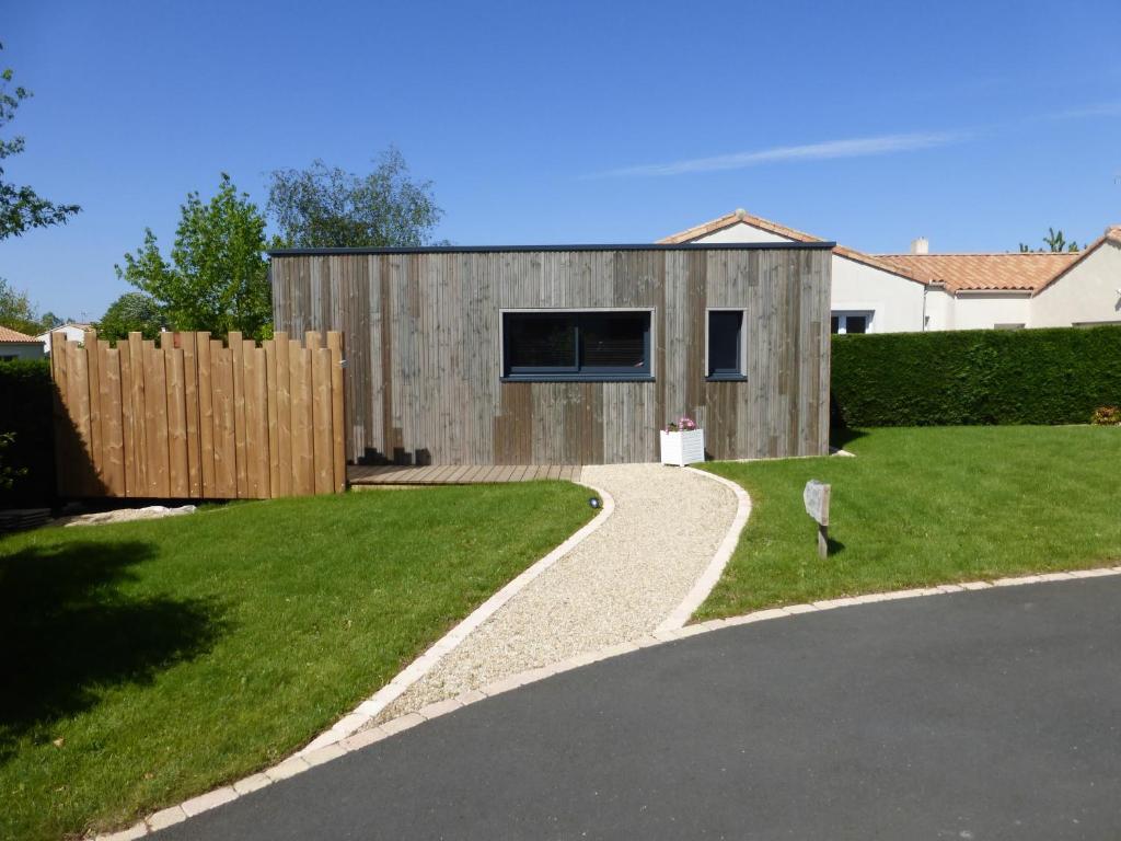 a house with a fence and a driveway at La cabane du Bonheur in Les Herbiers