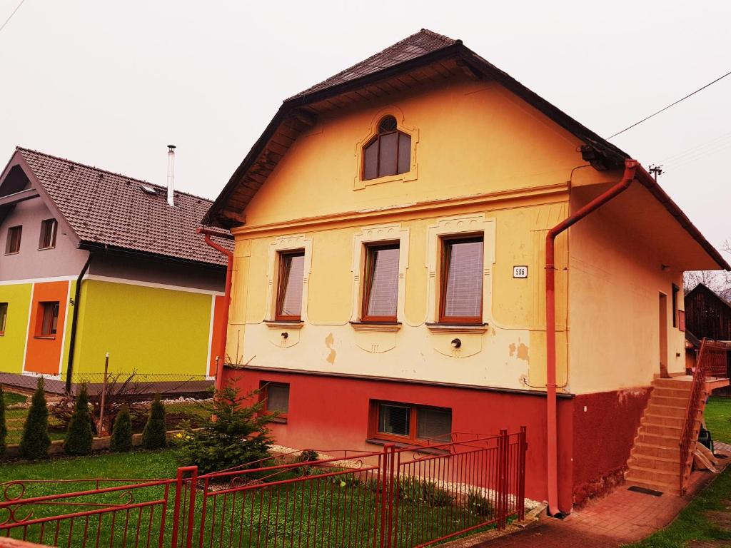 ein farbenfrohes Haus mit einem Zaun davor in der Unterkunft Privat DAŇO in Lisková