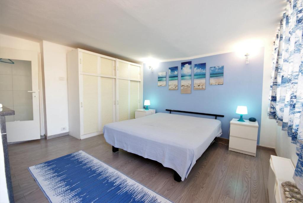 a bedroom with a white bed and a blue wall at Appartamento Manola in Sanremo