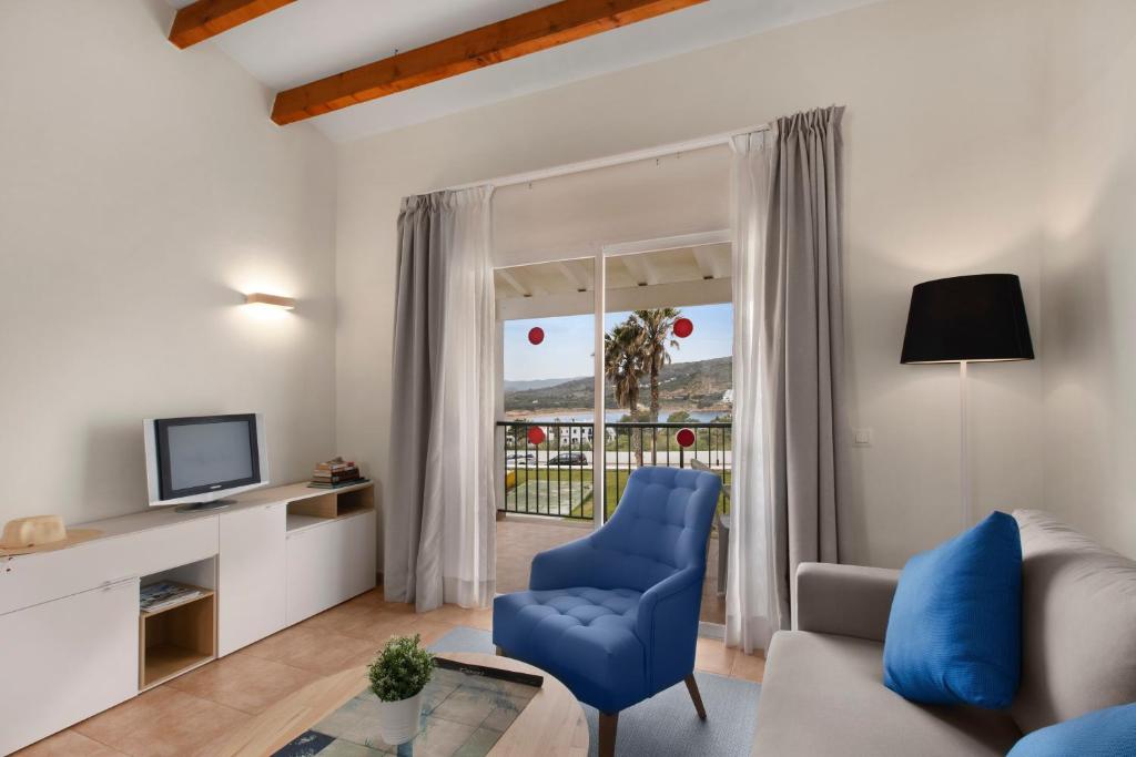 sala de estar con silla azul y TV en TRH Tirant Playa, en Fornells