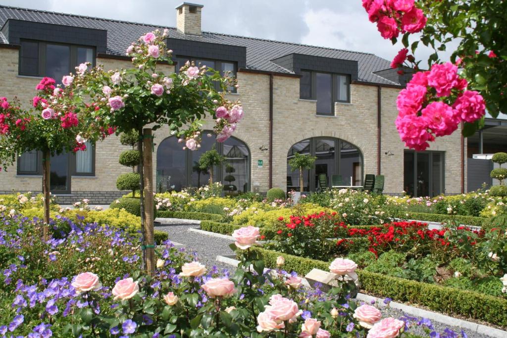 un jardin de fleurs devant un bâtiment dans l'établissement B&B La Vie En Roses, à Moorsel
