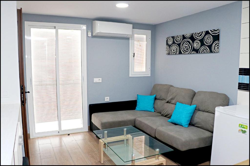 - un salon avec un canapé et une table en verre dans l'établissement Apartamento Baluarte, à Conil de la Frontera