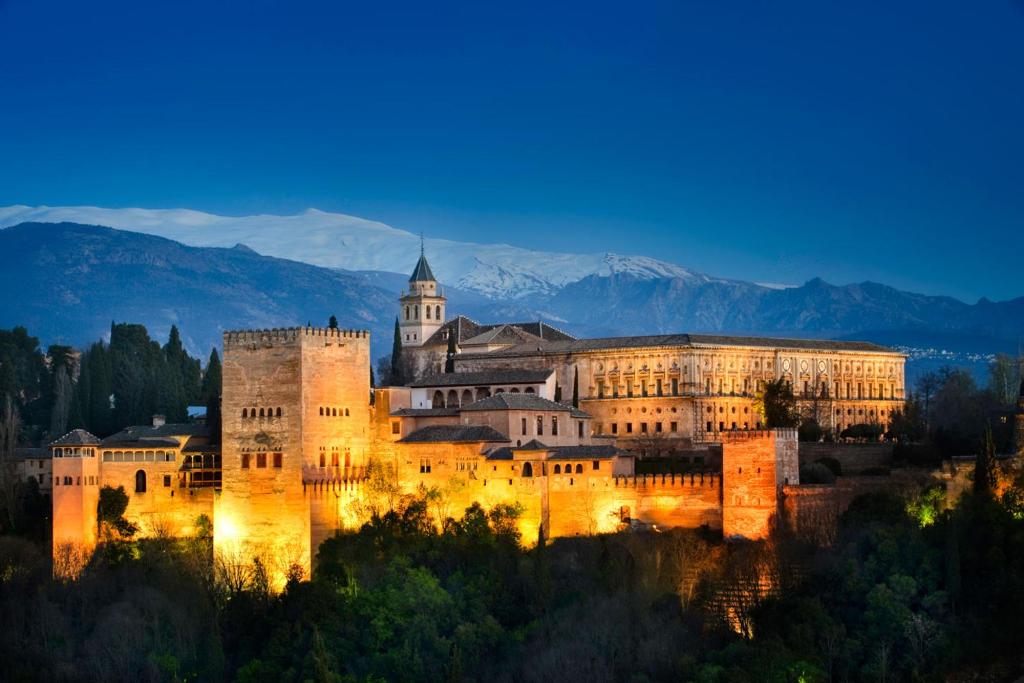 un gran castillo se sienta en una colina por la noche en Apartamento Castillo, en Granada