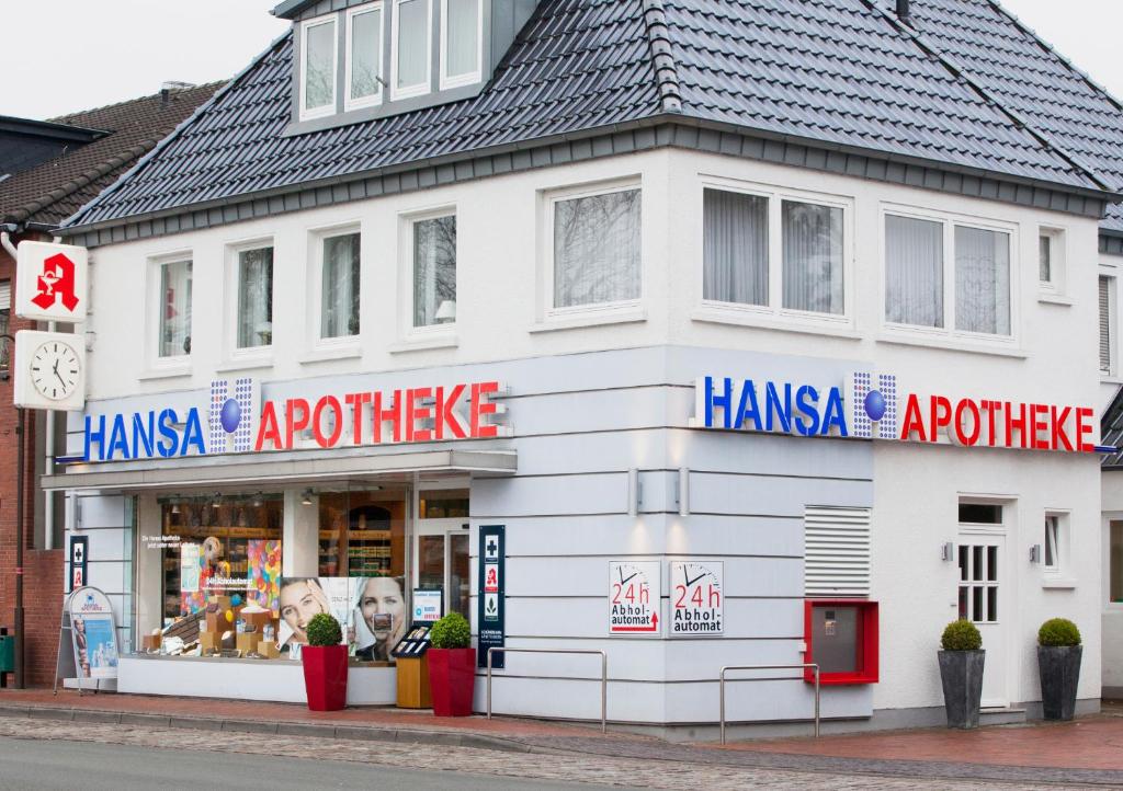 un edificio blanco en una calle con una tienda en Apothekerwohnung en Friesoythe