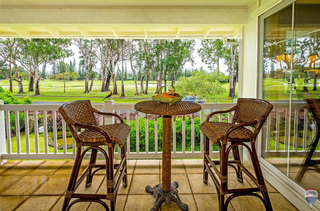 a porch with a table and two chairs and a window at Plantations at Princeville #521 in Princeville