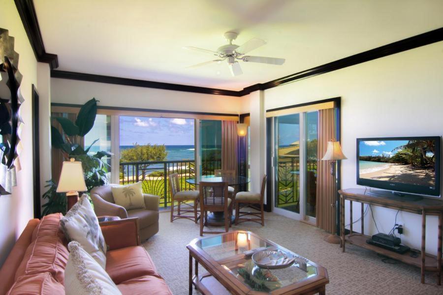 uma sala de estar com um sofá e uma televisão de ecrã plano em Waipouli Beach Resort G-306 em Kapaa