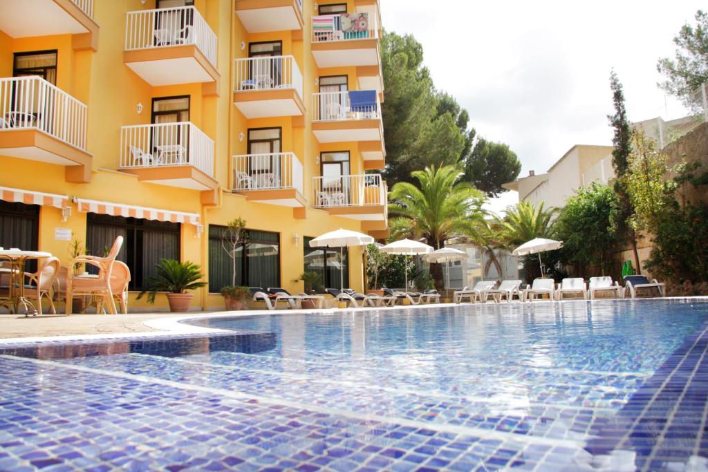 um hotel com piscina em frente a um edifício em Hotel Morlans em Paguera