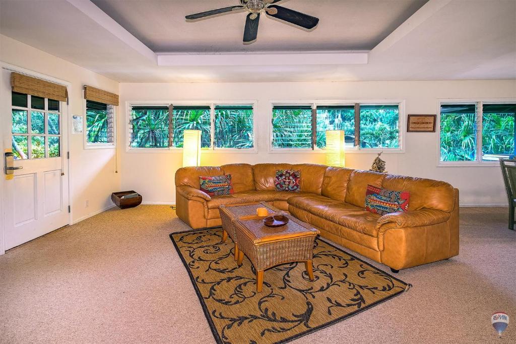 uma sala de estar com um sofá e uma mesa em Kauai Tree House em Wainiha