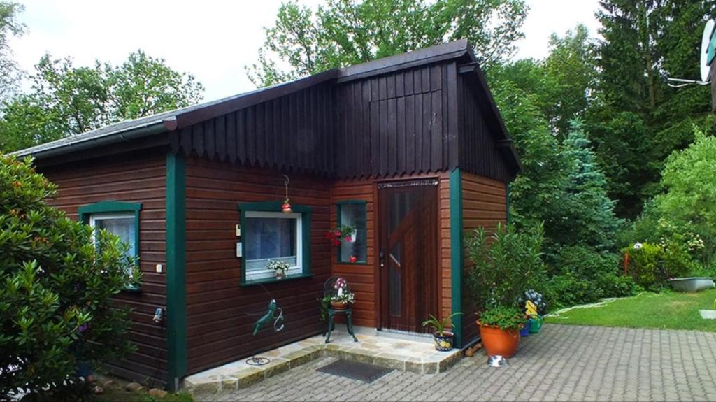 małą drewnianą kabinę w ogrodzie w obiekcie Höllenstiege w mieście Rathmannsdorf
