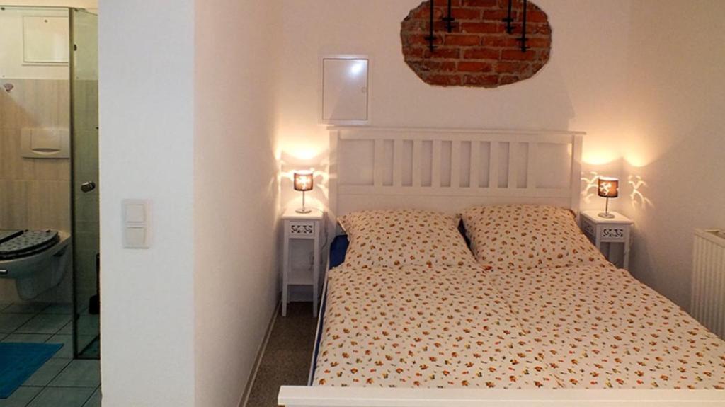 sypialnia z białym łóżkiem i 2 szafkami nocnymi w obiekcie Höllenstiege w mieście Rathmannsdorf