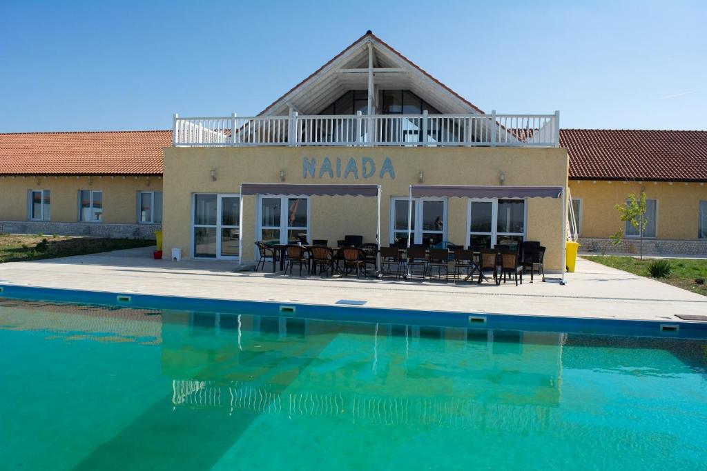 a house with a swimming pool in front of a building at Naiada in Ostrov