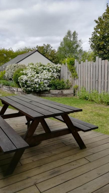 - une table de pique-nique en bois sur une terrasse fleurie dans l&#39;établissement La maison des bois flottés, à Guérande