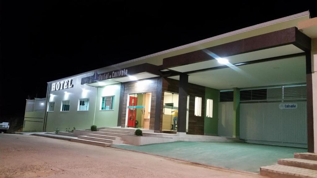 a building lit up at night with a red door at Hotel Portal do Corrente in Santa Maria da Vitória