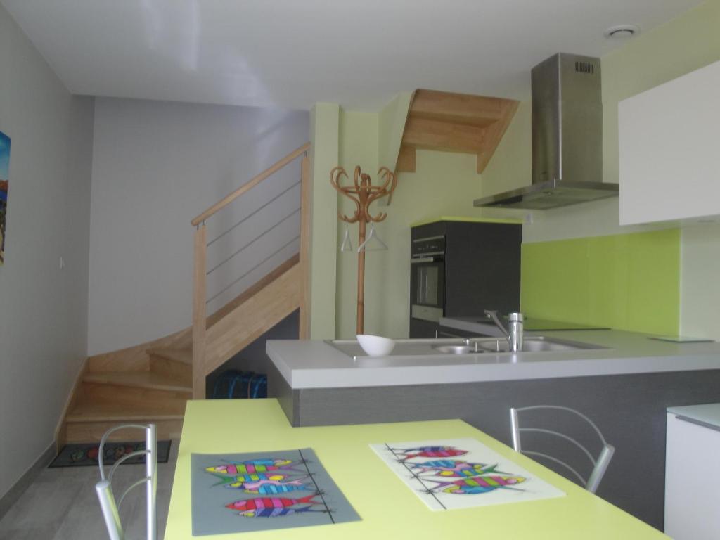 a kitchen with a yellow table and a sink at Maison de vacances in Concarneau