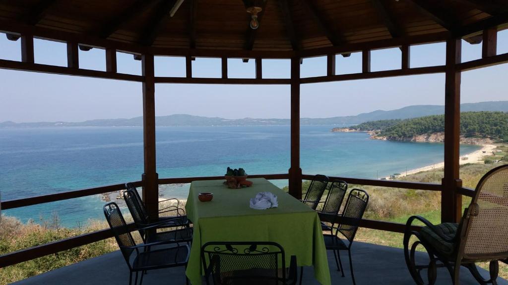 une table et des chaises dans une pièce avec vue sur l'océan dans l'établissement Villa Iviritiko, à Nea Roda