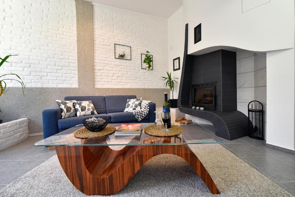 uma sala de estar com um sofá azul e uma mesa de centro em Apartment with fireplace and terrace em Zagreb
