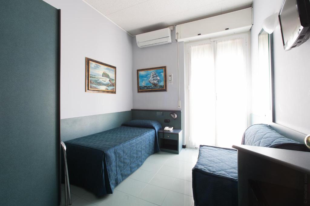 a small room with two beds and a window at Hotel Tirreno in Genoa