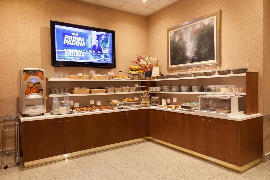 a food counter in a restaurant with a tv at Hotel Tirreno in Genoa
