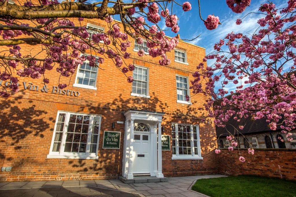 a brick building with a white door and a tree at Hotel Du Vin Stratford in Stratford-upon-Avon