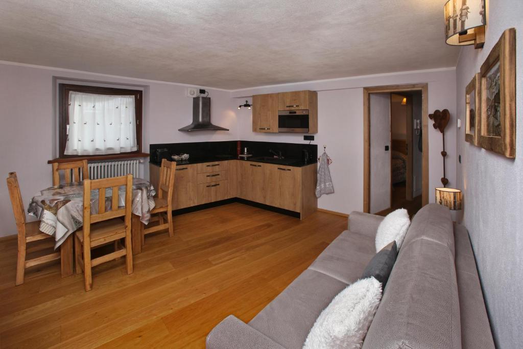 un soggiorno con divano e una cucina di Appartamenti Genevris a Sauze d'Oulx