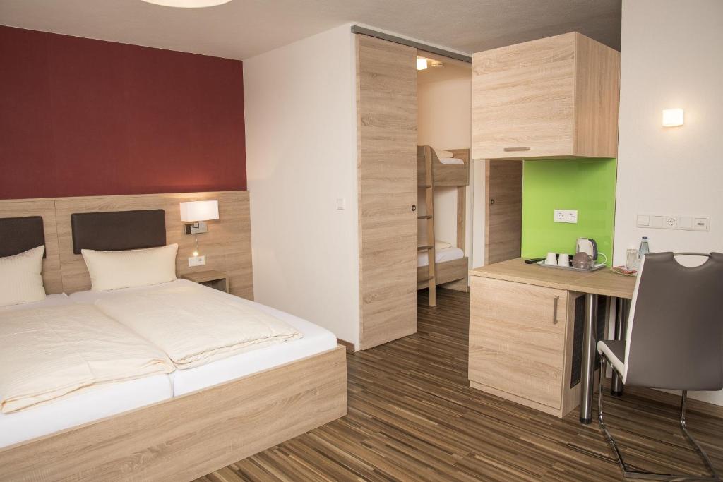 1 dormitorio con cama, escritorio y silla en Gasthof zum Goldenen Lamm en Wettelsheim