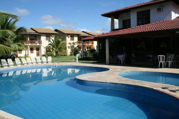 una piscina frente a una casa en Casa Porto Mar América Praia, en Porto Seguro