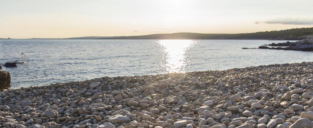 a large group of rocks on a beach near the water at Apartment Stefania on the beach in Koromačno