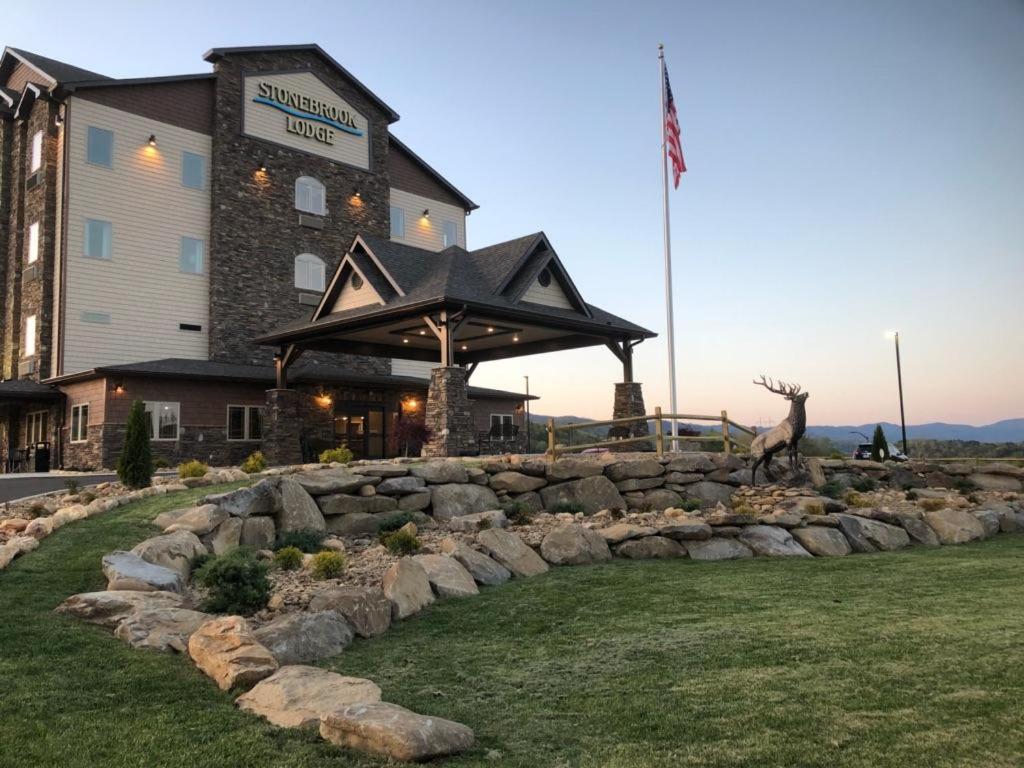 a building with a rock wall in front of a building at Stonebrook Lodge Murphy in Murphy
