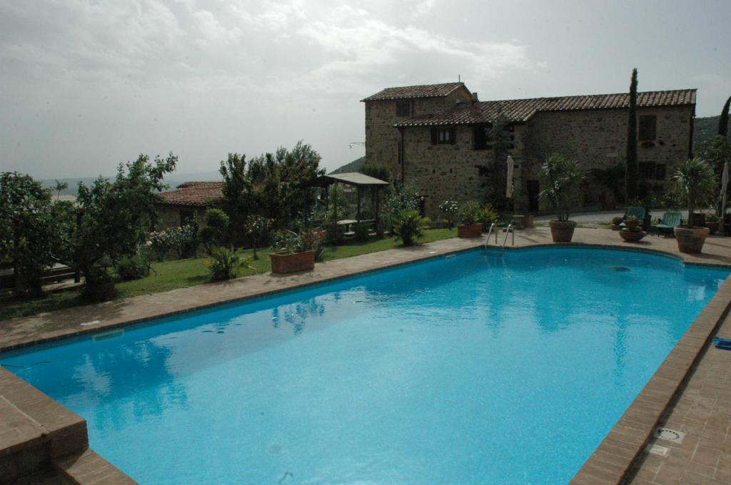 een groot blauw zwembad voor een gebouw bij La Palazzetta di Luca e Flavio in Castelnuovo dellʼAbate