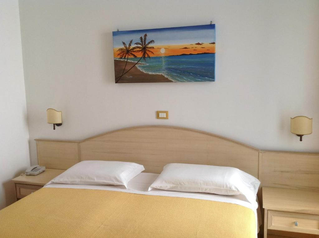 a bedroom with a bed and a painting on the wall at Hotel Corallo in Torre Santa Sabina