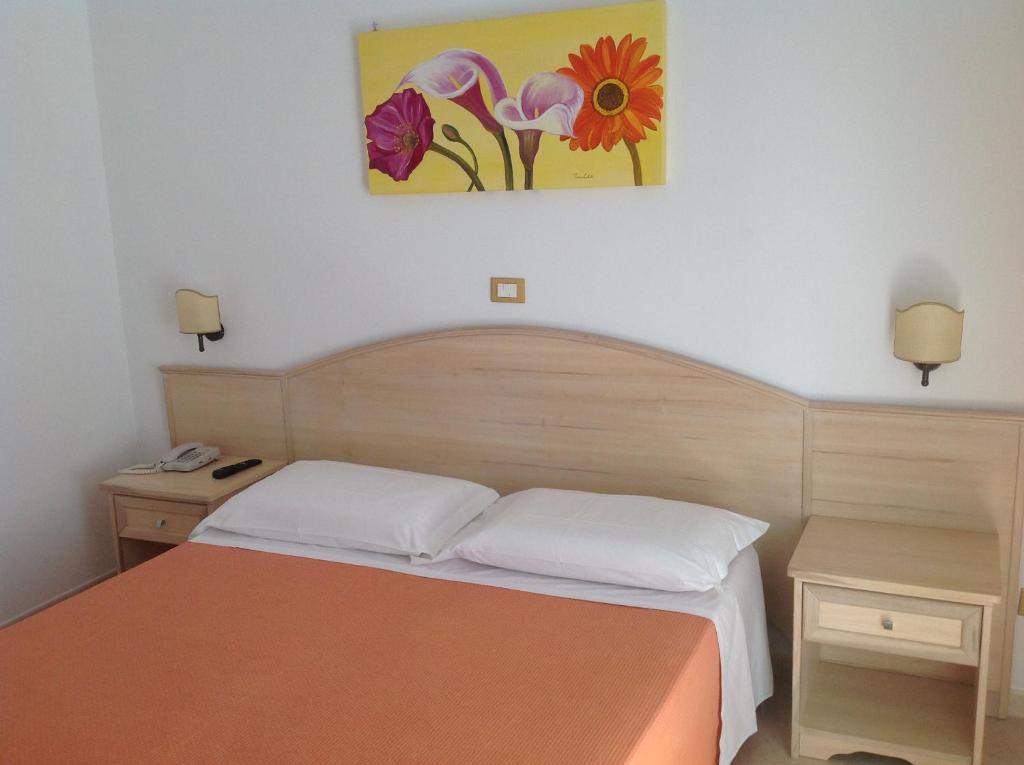 a bedroom with a bed and a painting on the wall at Hotel Corallo in Torre Santa Sabina