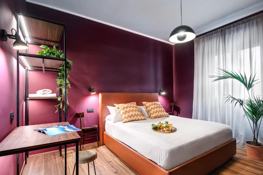 - une chambre avec un lit et un mur violet dans l'établissement Carusotto - Sorrento, à Sorrente