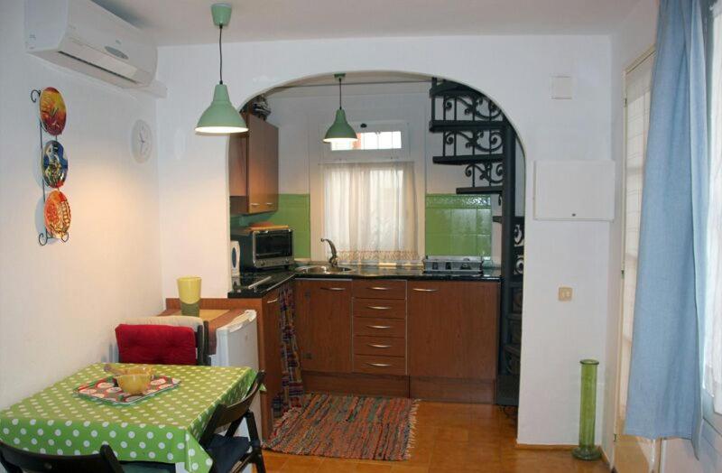 a kitchen with a table and a kitchen with an archway at Mini Apartamento Port Aiguadolç in Sitges