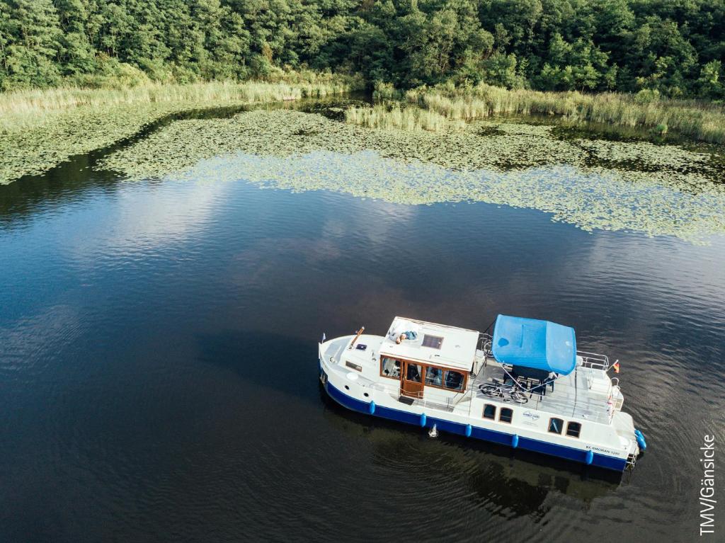 Ein Boot schwimmt auf einem Fluss in der Unterkunft Kuhnle-Tours Bootshaus Zeuthen in Zeuthen