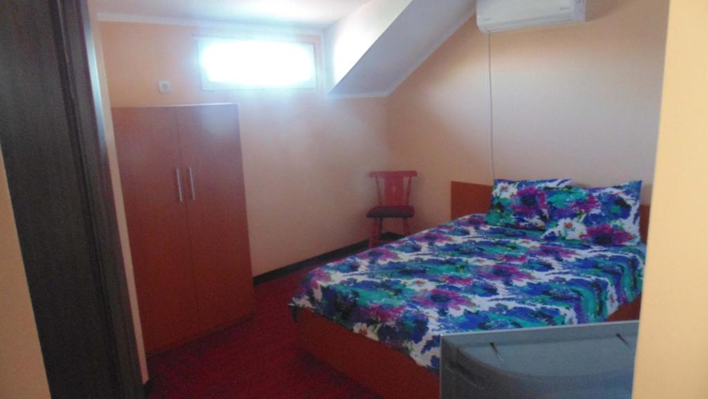 a small bedroom with a bed and a television at Vila Thetis in Mamaia Nord