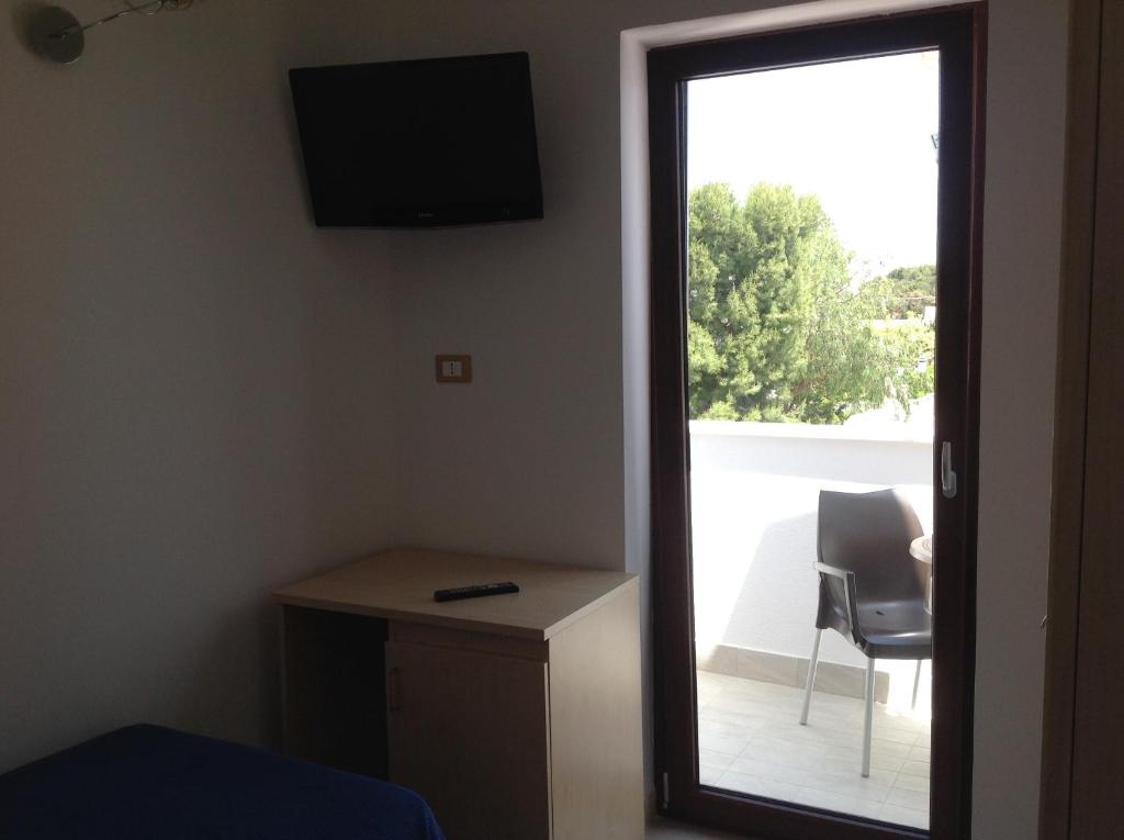 a room with a door leading to a balcony with a chair at Hotel Corallo in Torre Santa Sabina