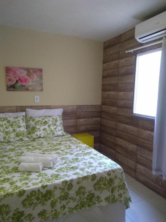 um quarto com uma cama com um cobertor verde e branco em Anauê Pousada e Hostel em Aracaju