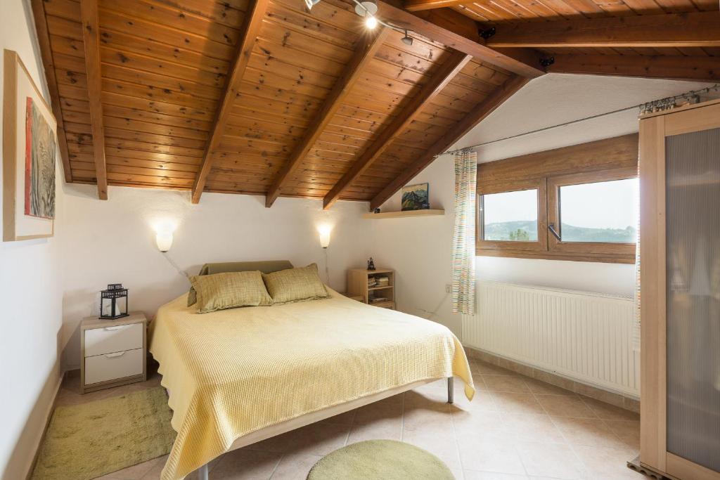 sypialnia z łóżkiem i drewnianym sufitem w obiekcie Beachside Haven, Poolside Serenity & Sunset Magic w mieście Kalandra