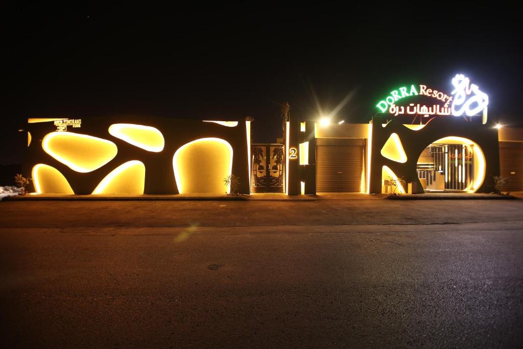 a building with a sign on the side of it at night at Dorrah Resort in Riyadh