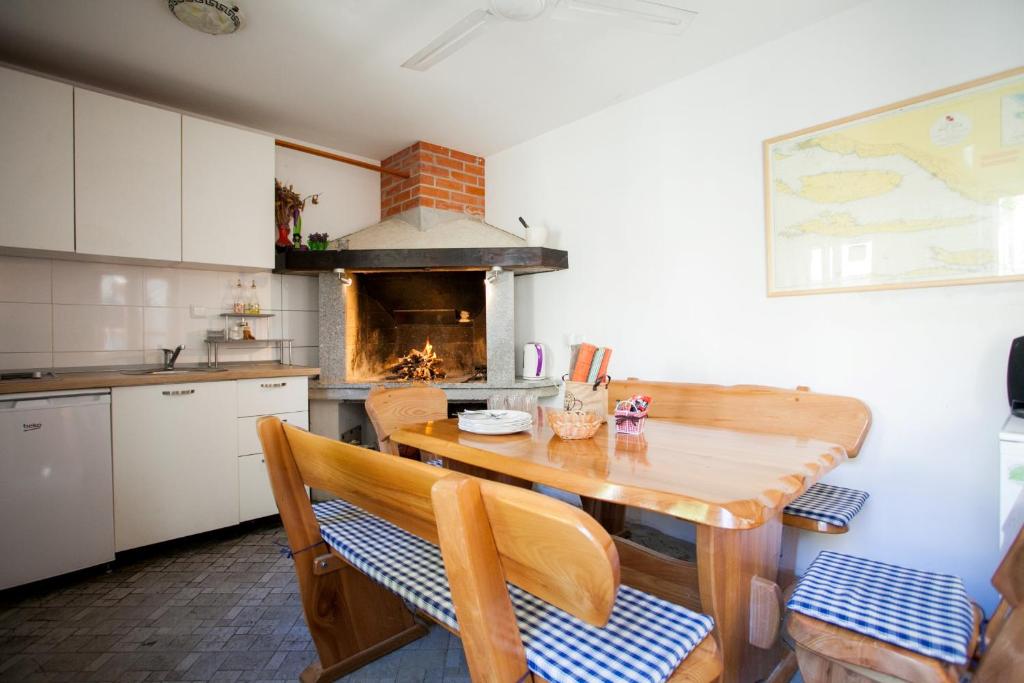 a kitchen with a wooden table and a fireplace at Apartments and Rooms Marino in Trogir
