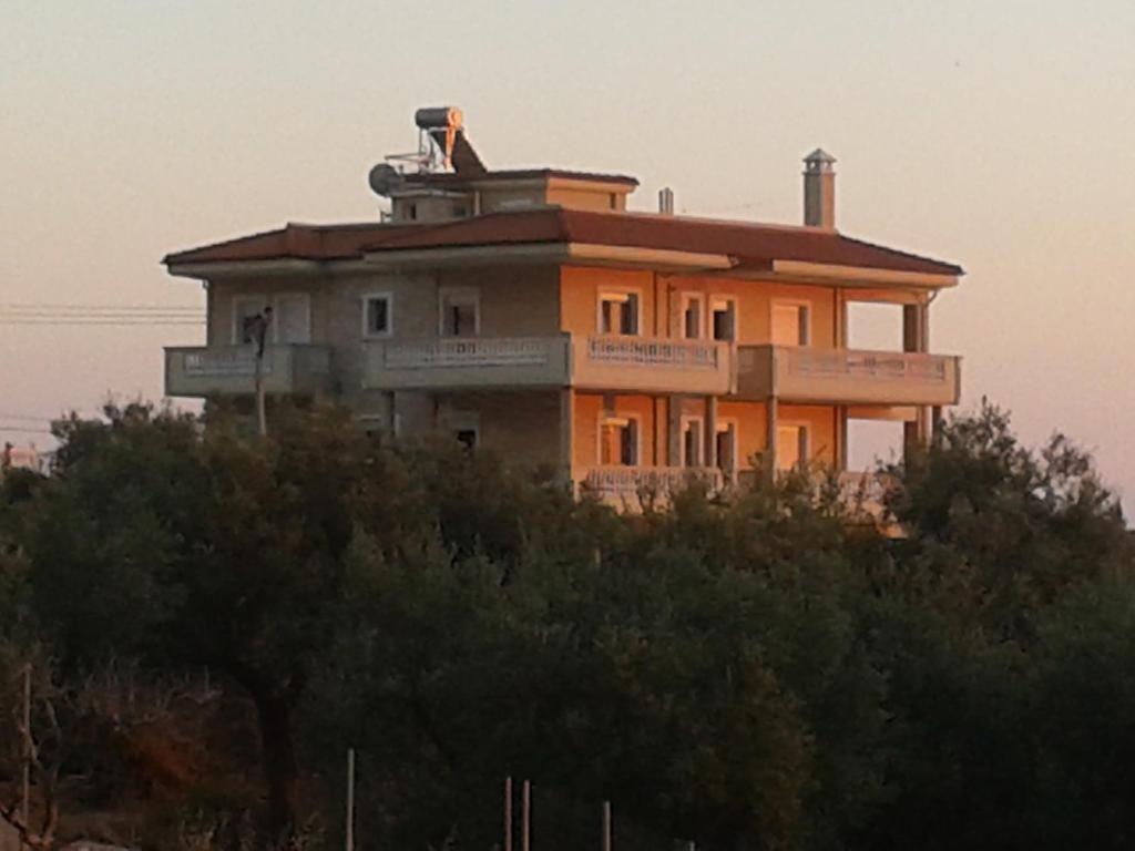 una casa en la cima de una colina con árboles en Spartila Apartments en Dhërmi