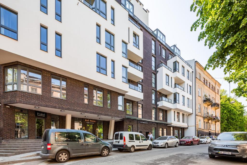 een straat met auto's geparkeerd voor gebouwen bij Central Park Apartments in Lviv