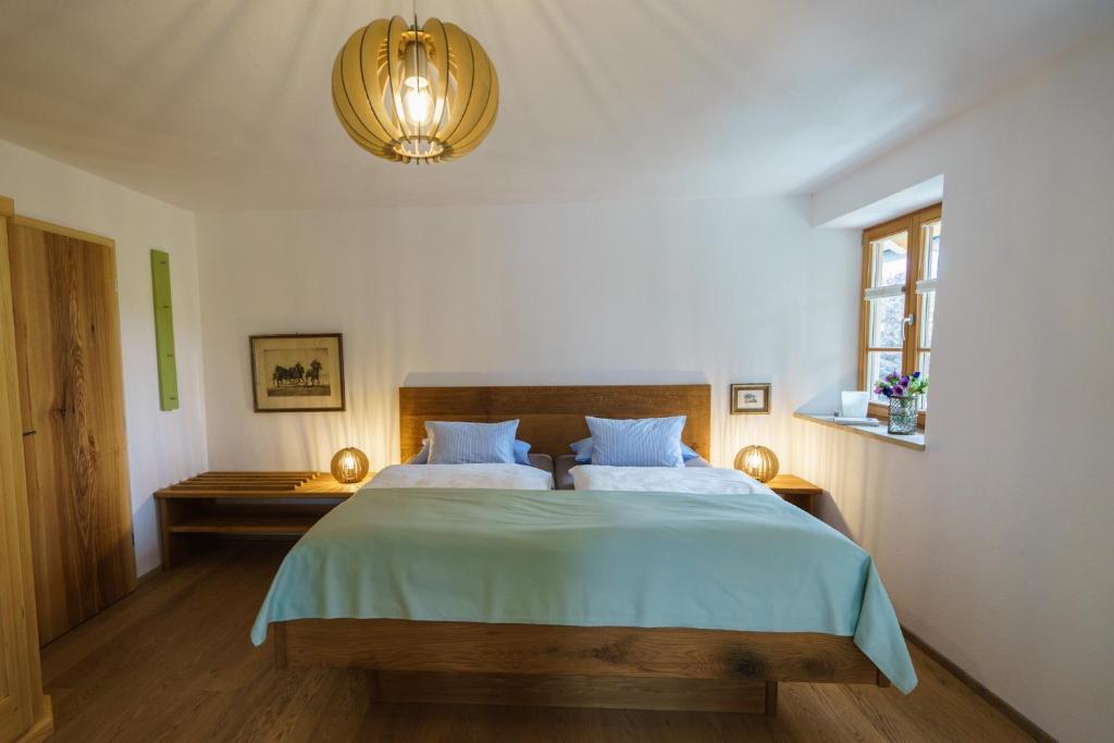 a bedroom with a large bed with a green blanket at Malerhaus am Kolbergarten in Bad Tölz